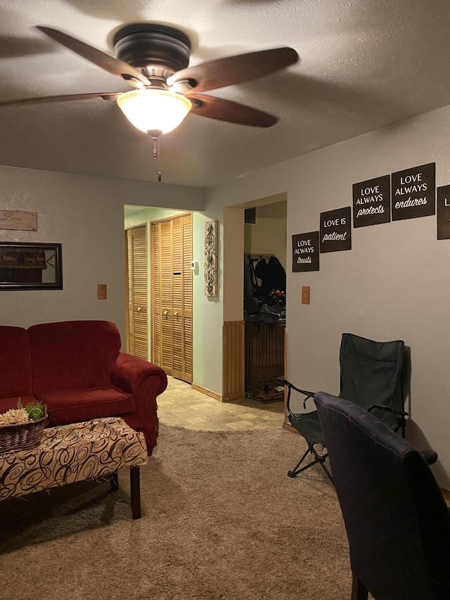 carpeted living room featuring a textured ceiling and ceiling fan