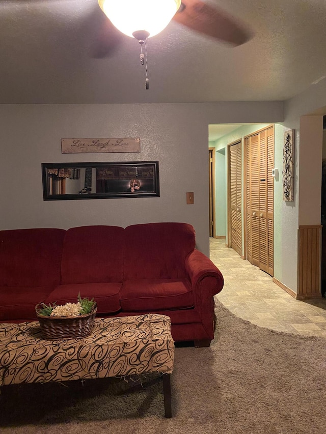 carpeted living room with ceiling fan