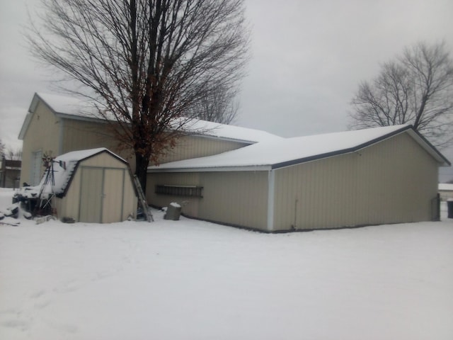 snow covered property with a storage unit