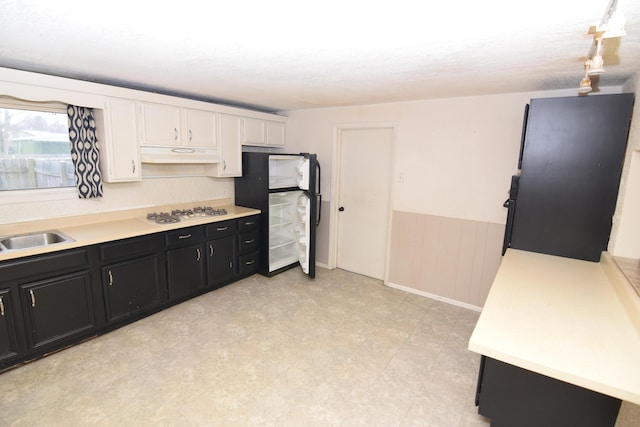 kitchen with fridge, sink, white cabinetry, and white gas stovetop