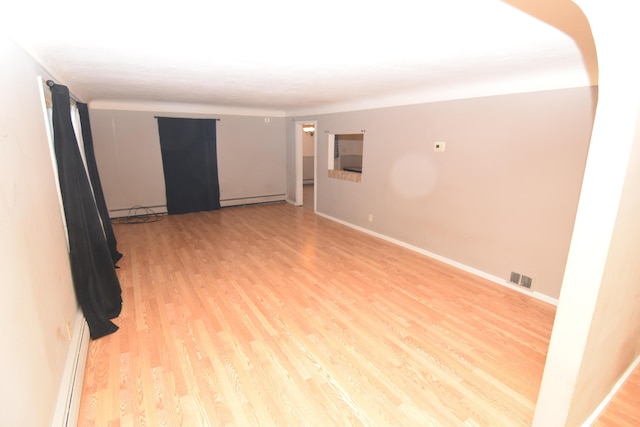 unfurnished room featuring light wood-type flooring and a baseboard radiator