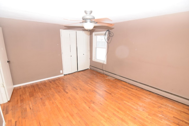 unfurnished bedroom with light wood-type flooring, ceiling fan, and a baseboard radiator