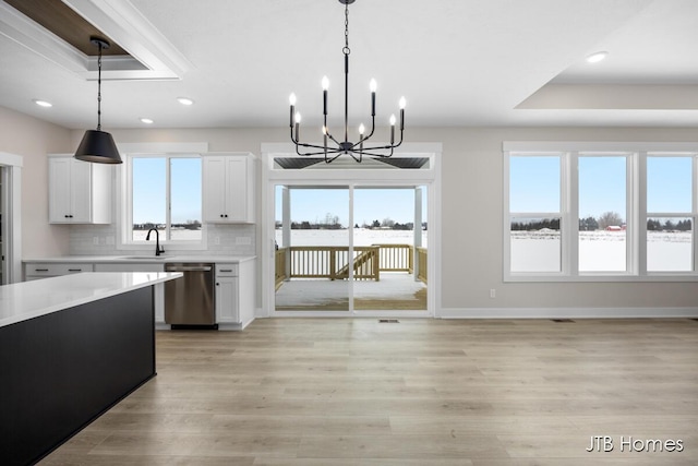 kitchen with pendant lighting, white cabinets, and dishwasher