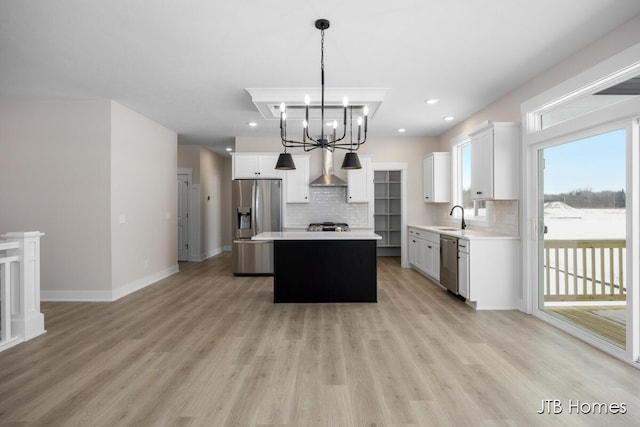 kitchen featuring sink, white cabinetry, hanging light fixtures, appliances with stainless steel finishes, and a kitchen island