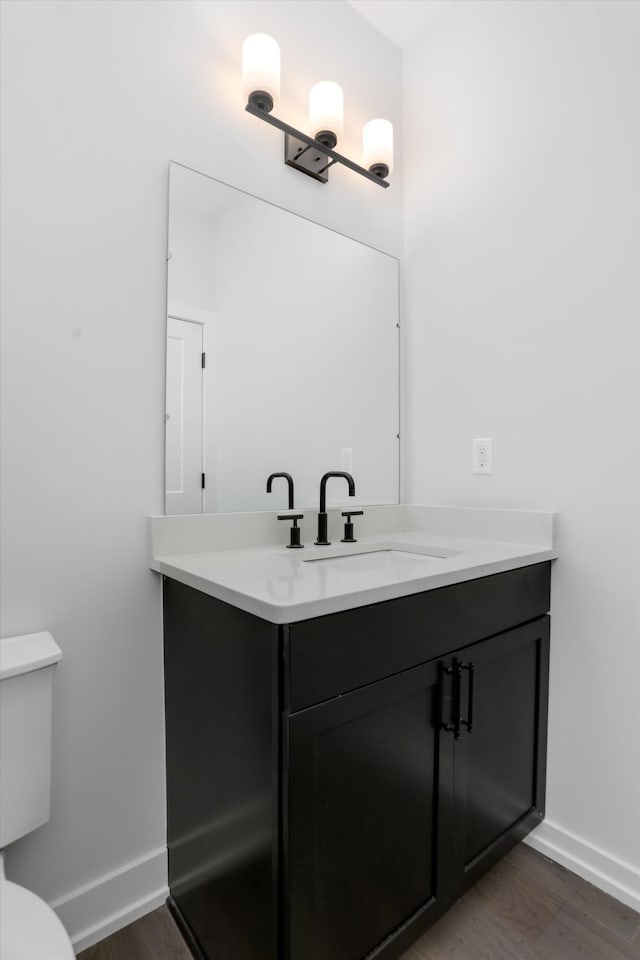 bathroom with vanity, hardwood / wood-style flooring, and toilet