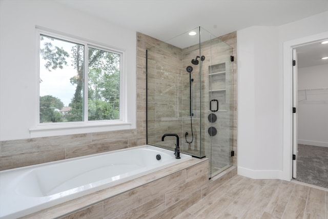 bathroom featuring wood-type flooring and independent shower and bath