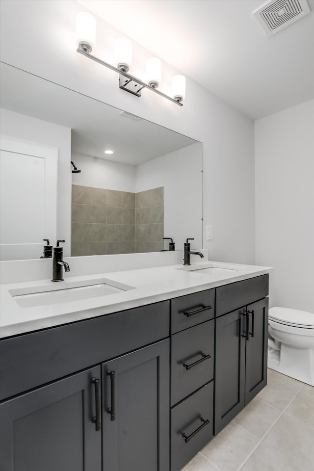 bathroom with tile patterned flooring, vanity, toilet, and a shower