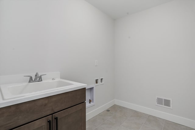 laundry area with washer hookup, light tile patterned flooring, cabinets, and sink