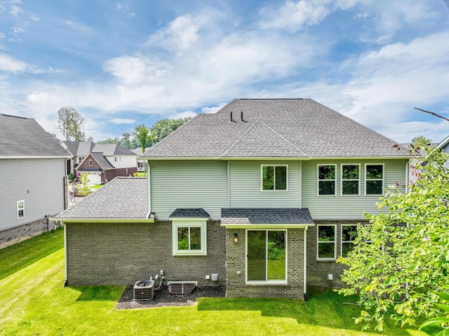 back of property with a yard and central AC unit