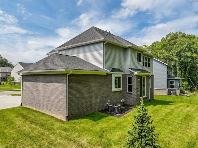 back of house with a lawn and cooling unit