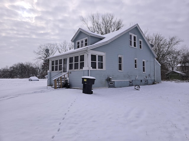 snow covered property featuring a sunroom