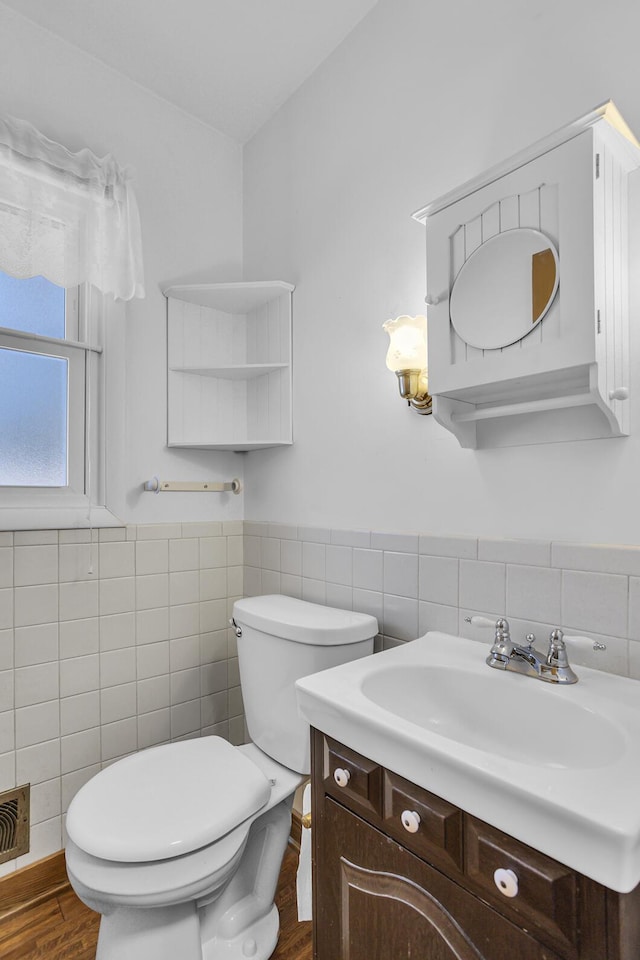 bathroom with vanity, hardwood / wood-style flooring, tile walls, and toilet