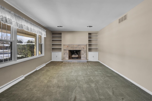 unfurnished living room with built in shelves, a baseboard radiator, carpet flooring, and a stone fireplace