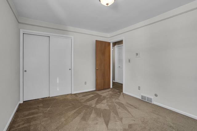 unfurnished bedroom featuring carpet flooring and a closet