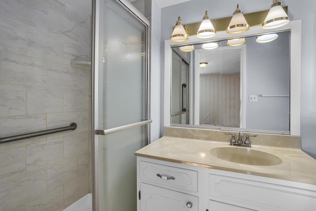 bathroom with a shower with shower door and vanity