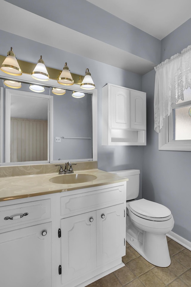 bathroom with toilet, tile patterned flooring, and vanity