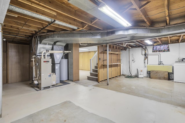 basement with washer / dryer, water heater, sink, wood walls, and heating unit