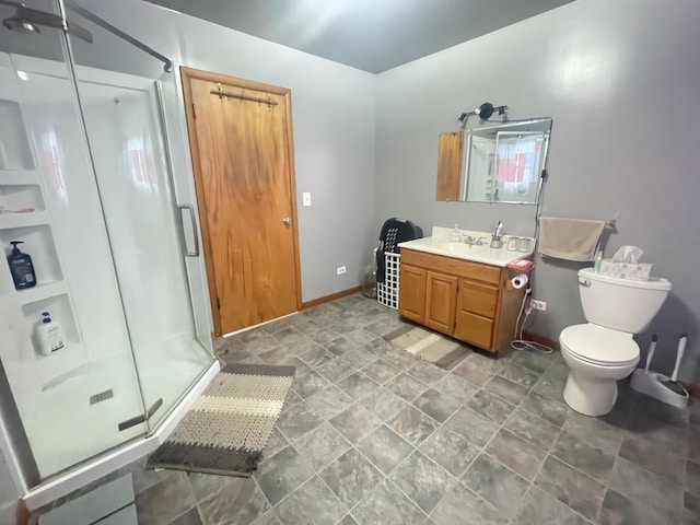 bathroom featuring toilet, a shower with shower door, and vanity