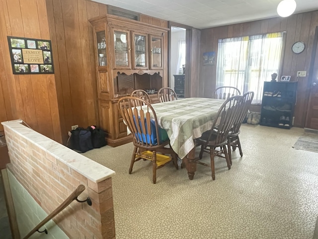 dining area featuring wood walls