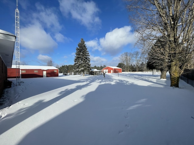 snowy yard featuring an outdoor structure