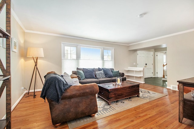 living room featuring light wood-type flooring and ornamental molding