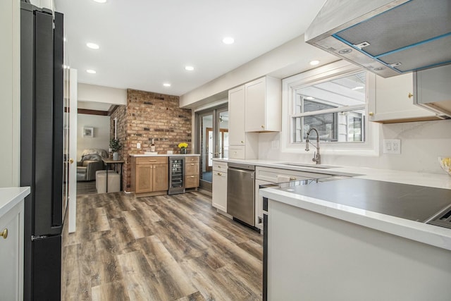 kitchen with sink, white cabinets, black fridge, extractor fan, and wine cooler