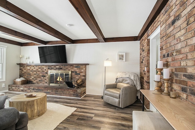 living room with beam ceiling, dark wood-type flooring, and a brick fireplace