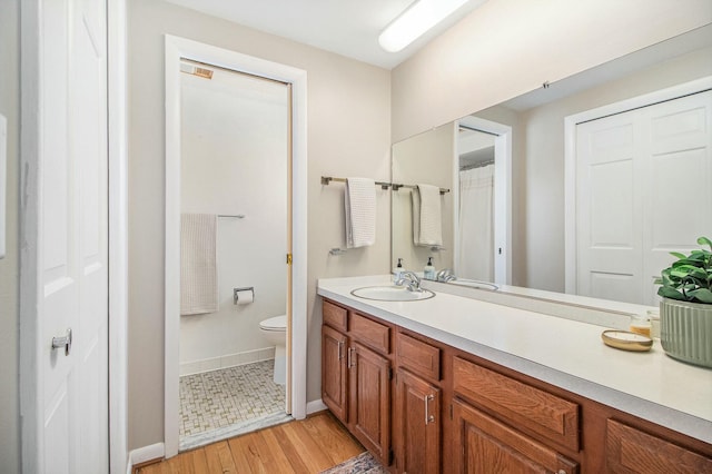 bathroom with wood-type flooring, vanity, and toilet