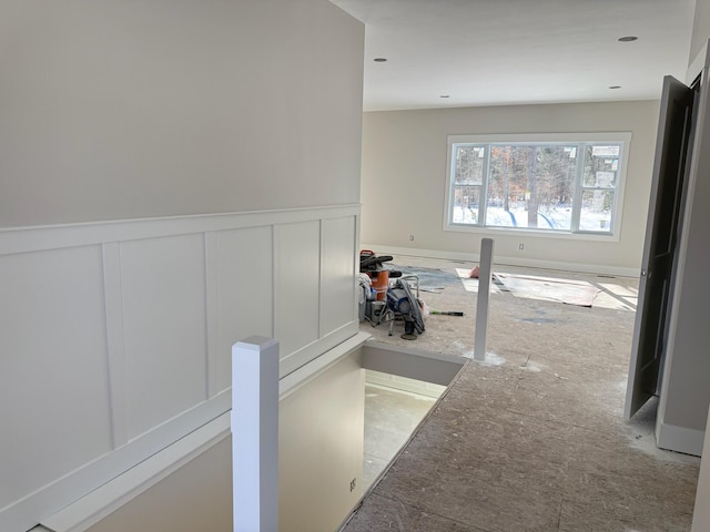 hallway with a wainscoted wall and a decorative wall