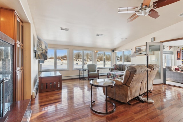 living room featuring ceiling fan, hardwood / wood-style floors, lofted ceiling, and a baseboard heating unit