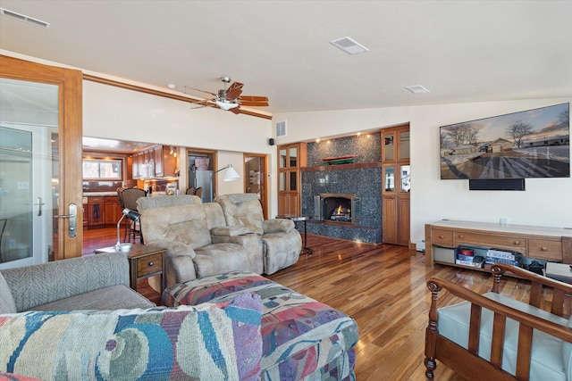 living room featuring ceiling fan, a premium fireplace, lofted ceiling, and hardwood / wood-style flooring