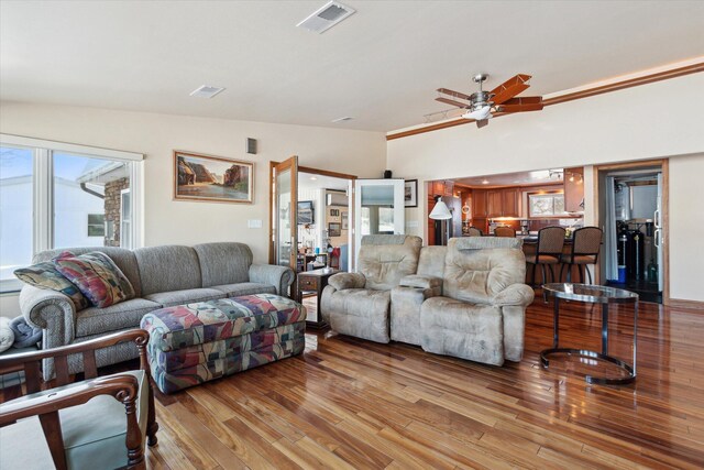 living room with lofted ceiling, ceiling fan, and light hardwood / wood-style floors