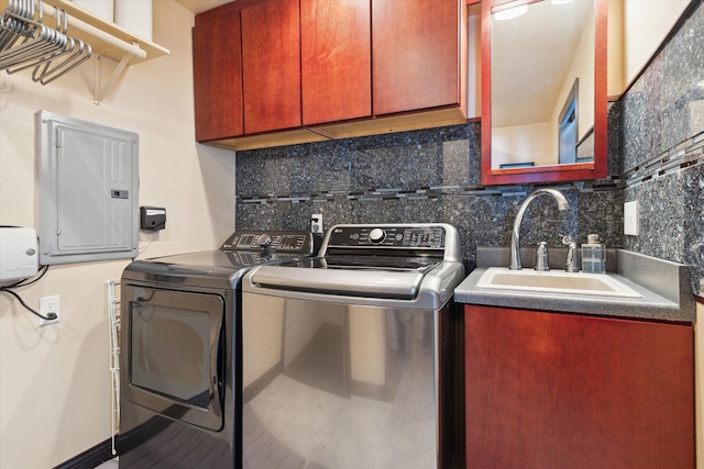 laundry area featuring electric panel, washer and dryer, cabinets, and sink