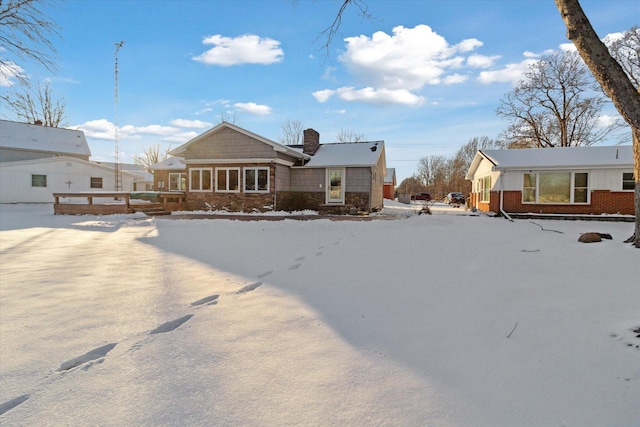 view of snow covered back of property