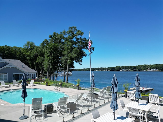 view of swimming pool featuring a water view and a patio