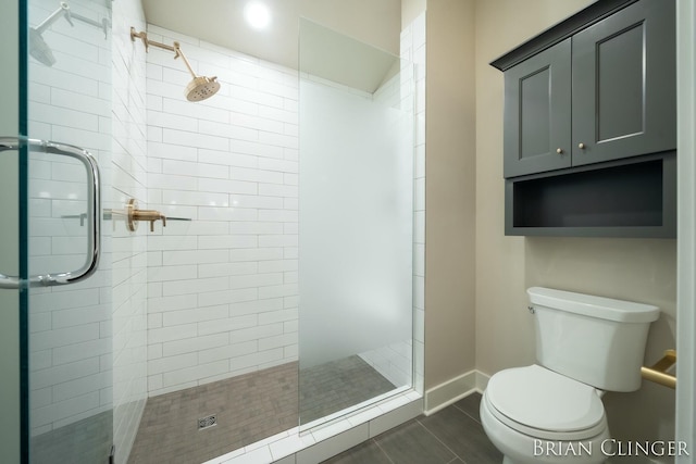 bathroom featuring tiled shower, toilet, and tile patterned flooring