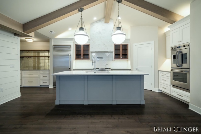 kitchen with pendant lighting, sink, appliances with stainless steel finishes, white cabinetry, and vaulted ceiling with beams