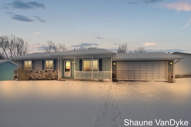 ranch-style home featuring a garage and covered porch