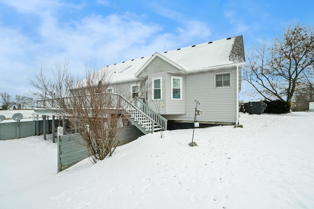 view of snow covered back of property