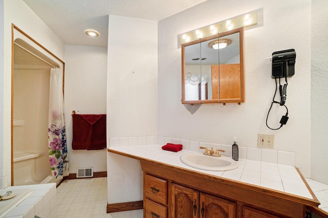 bathroom with a shower with shower curtain and vanity