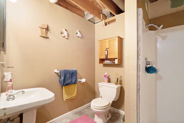 bathroom with toilet, walk in shower, and sink