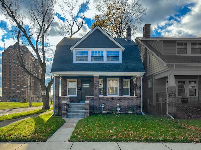 view of front of property with a porch and a front lawn