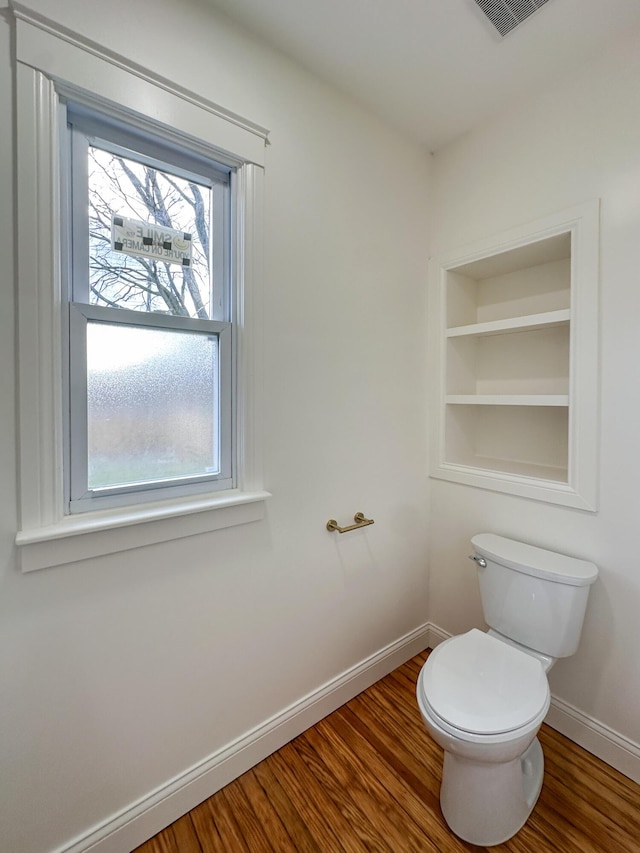 bathroom with toilet, hardwood / wood-style floors, and built in shelves