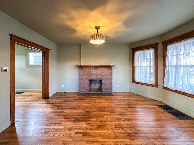 unfurnished living room featuring a fireplace, hardwood / wood-style flooring, and plenty of natural light