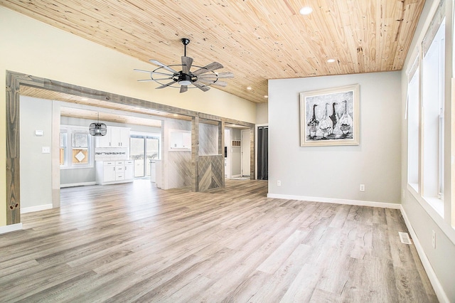 unfurnished living room with a barn door, wood ceiling, ceiling fan, light wood-type flooring, and baseboards