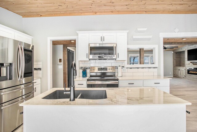 kitchen with stainless steel appliances, wood ceiling, white cabinetry, and decorative backsplash