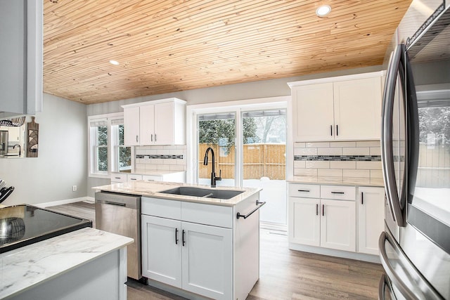 kitchen with white cabinets, decorative backsplash, dishwasher, fridge, and a sink