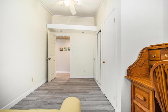 corridor featuring ornamental molding, wood finished floors, and baseboards