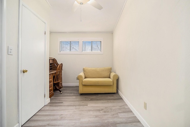 sitting room featuring baseboards, crown molding, a ceiling fan, and light wood-style floors