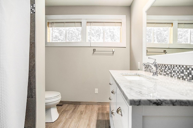 full bath featuring a healthy amount of sunlight, toilet, and wood finished floors